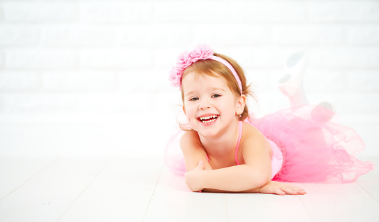 little child girl dreams of becoming  ballerina in a pink tutu skirt