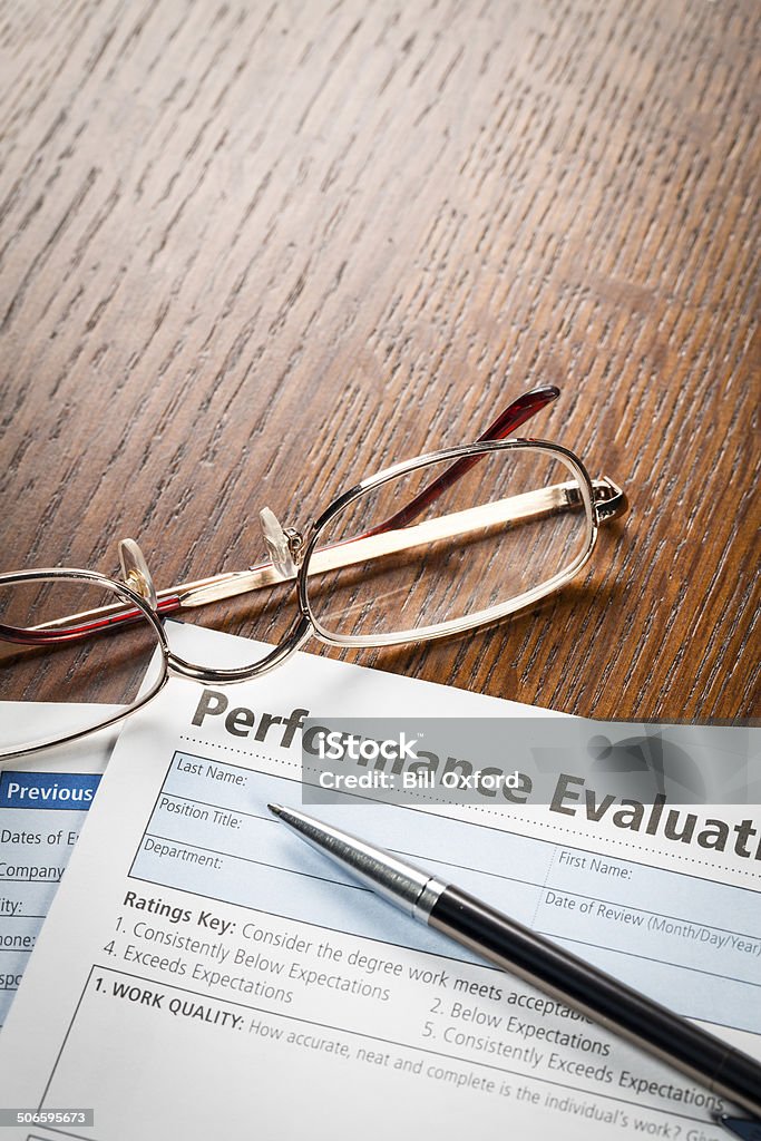 Performance Evaluation Performance Evaluation document with pen and glasses on note pad. Performance Review Stock Photo