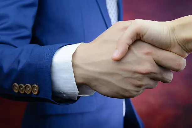 businessman in blue suit reaching hand to shake hands, make a business deal concept