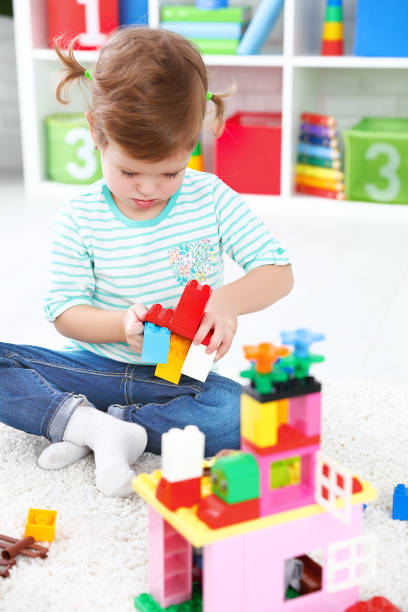 istock child girl playing with toys and builds constructor 506598324