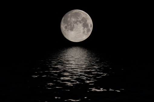 Full moon reflected water over dark black sky at night