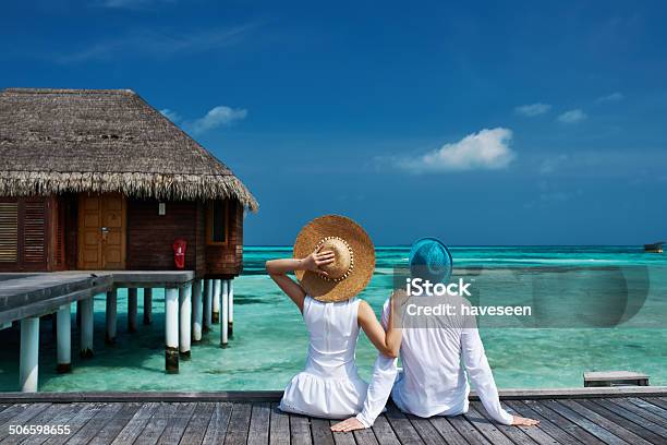 Coppia Su Un Molo Spiaggia A Maldive - Fotografie stock e altre immagini di Relazione di coppia - Relazione di coppia, Isole Maldive, Viaggio