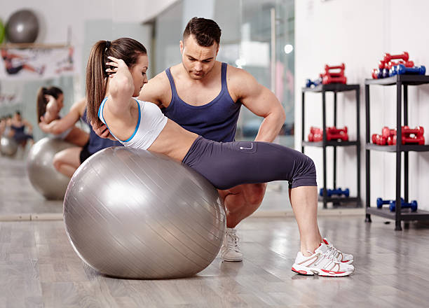 istock Personal trainer helping woman at gym 506599074