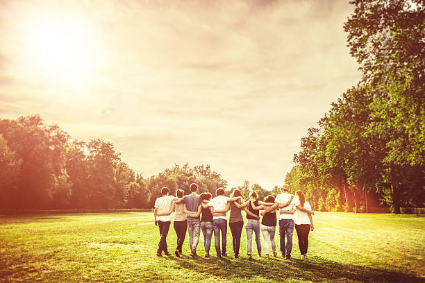 Group of Teenage Friends in the Park at Sunset Group of Teenage Friends in the Park at Sunset arm in arm stock pictures, royalty-free photos & images