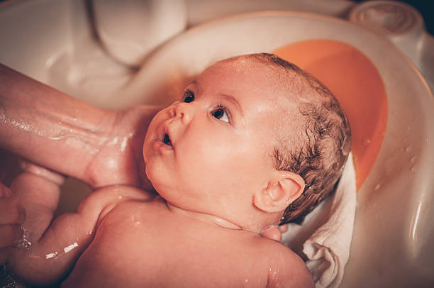 istock Small baby first bathing on father hands 506600444