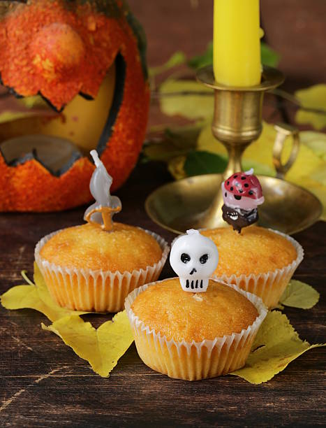 istock traditional halloween treats cupcakes with funny candles 506602425