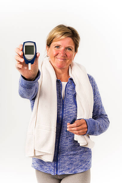 diabético feliz, mujer sostiene un glucómetro. - glaucometer fotografías e imágenes de stock