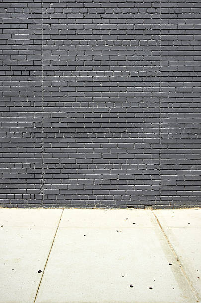 istock Black brick wall and concret floor 506605776