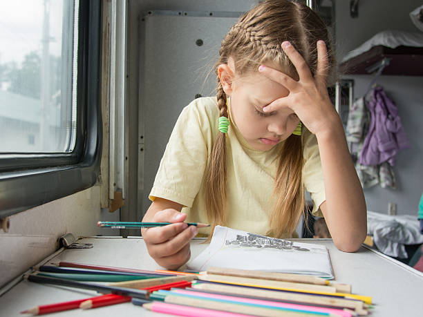 istock Six year old girl thoughtfully draws pencils in second-class 506609050