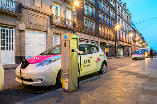 Mexico City, Mexico - January 11, 2016: Electric Nissan Leaf taxi is being charged at a charging station in downtown Mexico City, Mexico.
