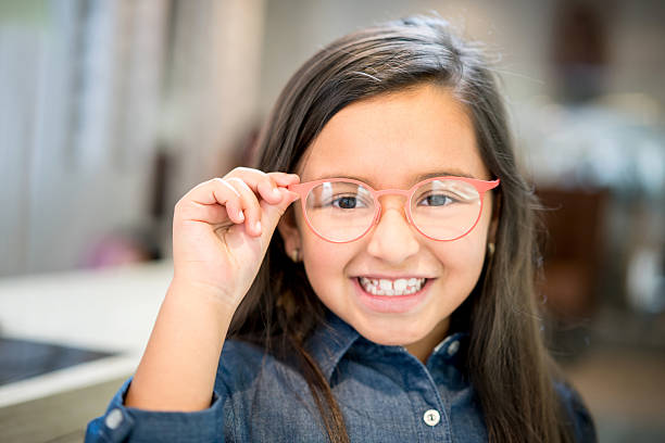 眼鏡で眼鏡を試みる女の子 - patient happiness cheerful optometrist ストックフォトと画像