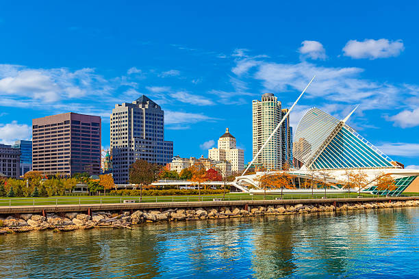Skyscrapers of Milwaukee skyline and Lake Michigan, WI Lake Michigan with reflections fills the foreground leading back to the skycrapers of Milwaukee skyline , Wisconsin milwaukee wisconsin stock pictures, royalty-free photos & images