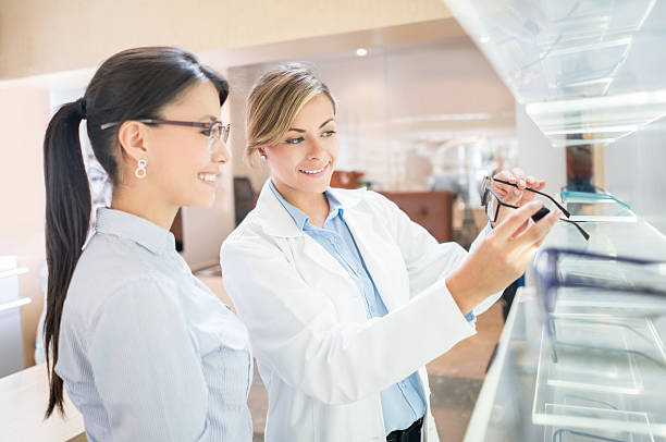 optician helping patient shopping for glasses - patient happiness cheerful optometrist imagens e fotografias de stock