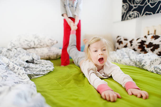 Two little sisters playing in bed