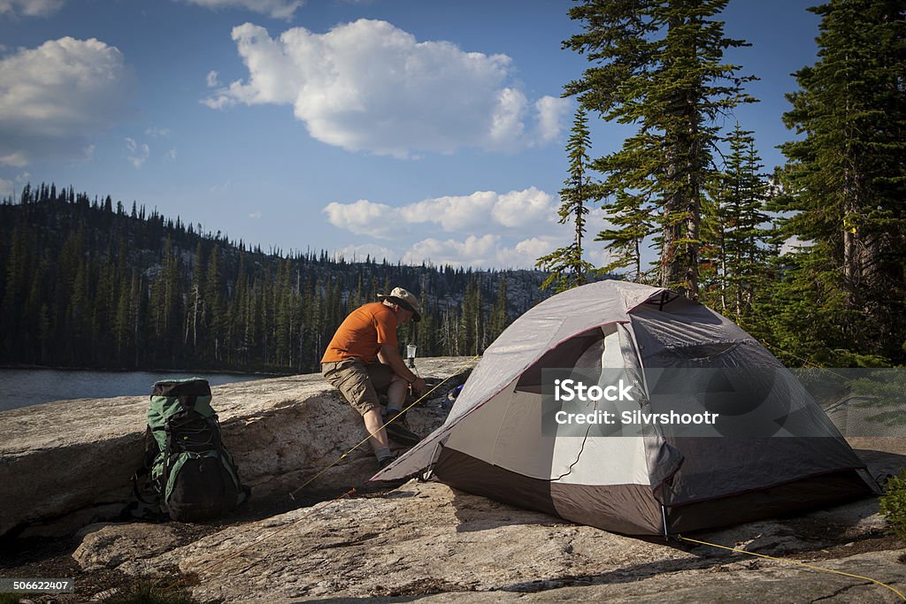 Backpacker is starting to make dinner on his stove. At his campsite alongside a mountain lake, a man is starting his stove in order to make dinner. Baseball Pitcher Stock Photo