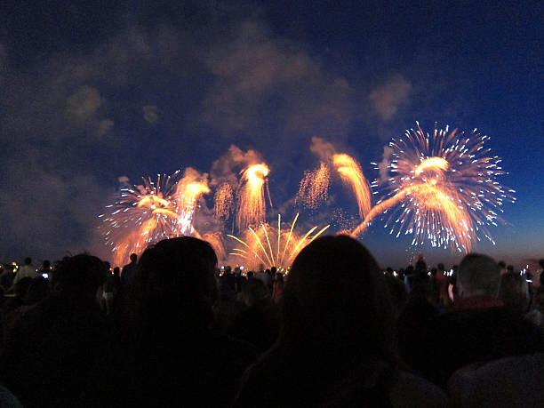 istock Heads of crowd silhouetted against a bright fireworks display 506623823