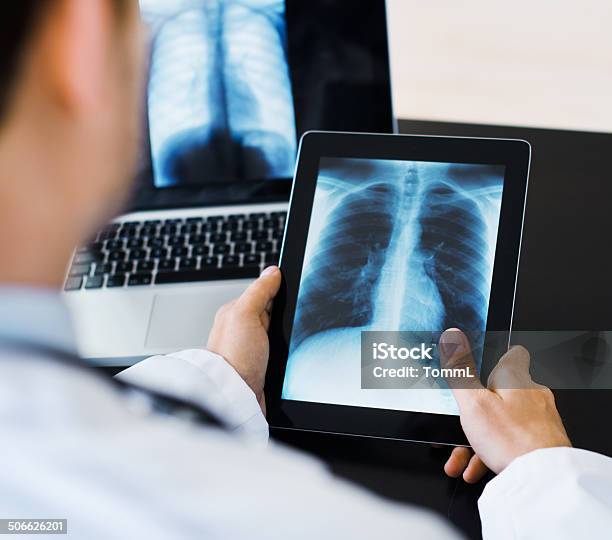 Doctor Using Digital Tablet Viewing Medical Scan Stock Photo - Download Image Now - Digital Tablet, X-ray Image, Doctor