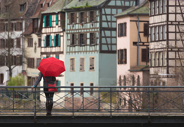 Young woman with umbrella on bridge in Strasbourg stock photo