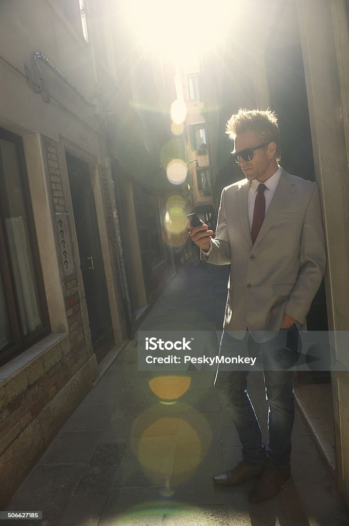 Europea alla moda giovane uomo utilizzando il telefono cellulare all'aperto - Foto stock royalty-free di Adulto