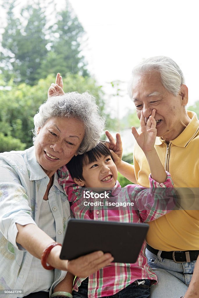 Wnuk i dziadkowie robią selfie z tablet - Zbiór zdjęć royalty-free (Fotografika)