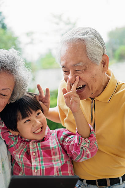 istock Grandson and grandparents taking selfie with digital tablet 506627221