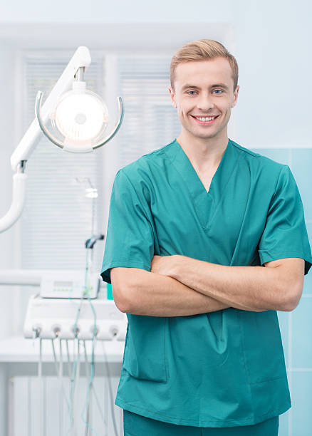 istock Young dentist smiling at his dental office 506650759