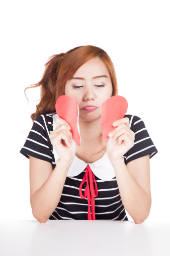 Sad Asian girl tear heart shape paper  isolated on white background