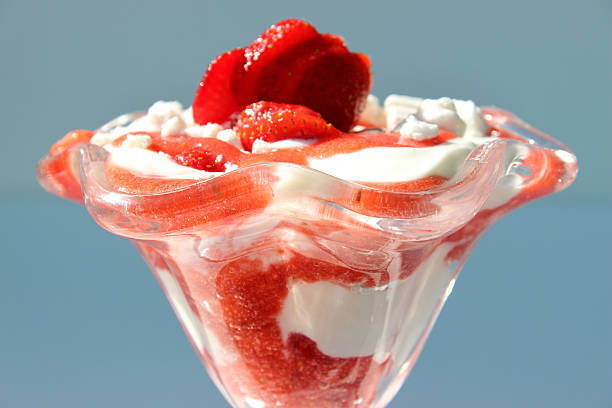 Image of Eton mess desert, strawberries, cream, meringue, mixed together Photo showing a bowl of Eton mess, served as a fresh summer dessert and comprising whipped cream, blended strawberry puree, chopped strawberries and crushed meringue, all mixed together to form a pattern of swirls. The Eton mess is then served in glass dishes and topped with strawberry slices. strawberry crush stock pictures, royalty-free photos & images