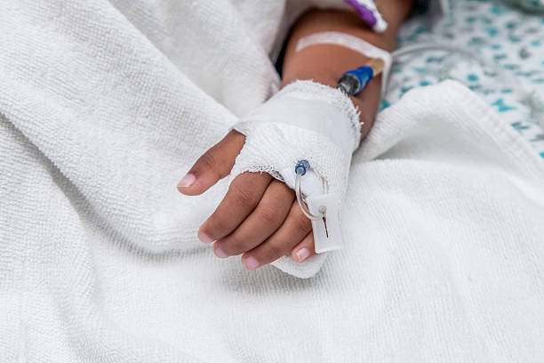istock Child's patient hand with saline intravenous (iv) drip 506662208