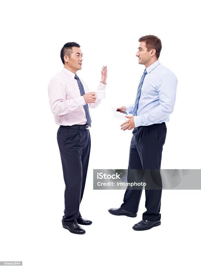 asian and caucasian businessmen talking asian and caucasian corporate executives standing and talking, isolated on white background. Talking Stock Photo