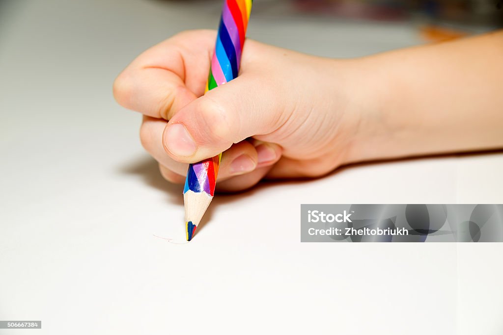 Kid's rigth hand holding a pencil on over white Kid's rigth hand holding a pencil on a white Color Image Stock Photo