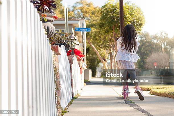 Foto de Menina Andando De Moto Ao Longo Da Calçada Seu e mais fotos de stock de Casa - Casa, Criança, Exterior