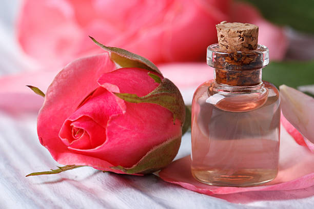 Rose water and pink beautiful flower macro horizontal Rose water and pink beautiful flower on a wooden table macro horizontal cork material photos stock pictures, royalty-free photos & images