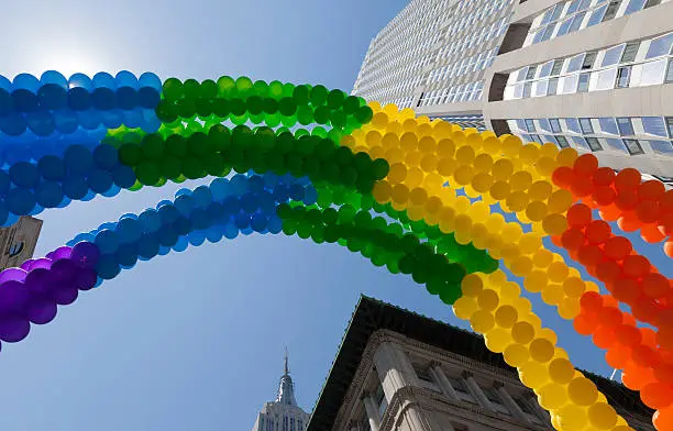 Rainbow LGBT balloons on street of New York with Empire State Building on background