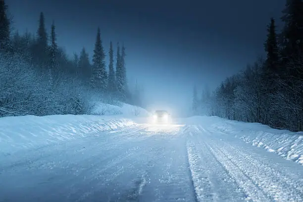 Photo of Car lights in winter Russian forest