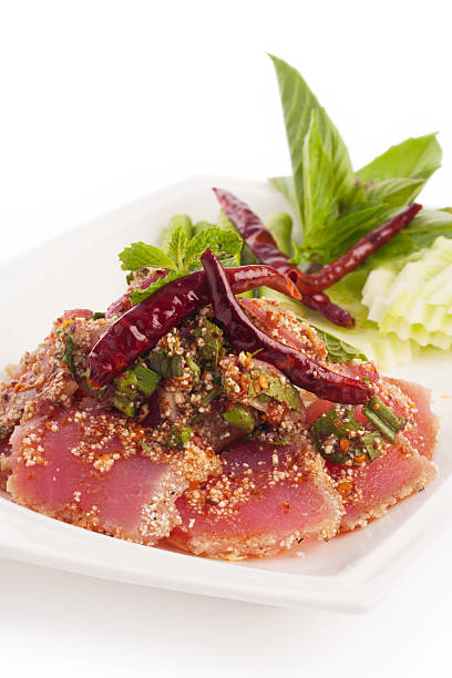 spicy fresh tuna tataki thai style with vegetable on white.