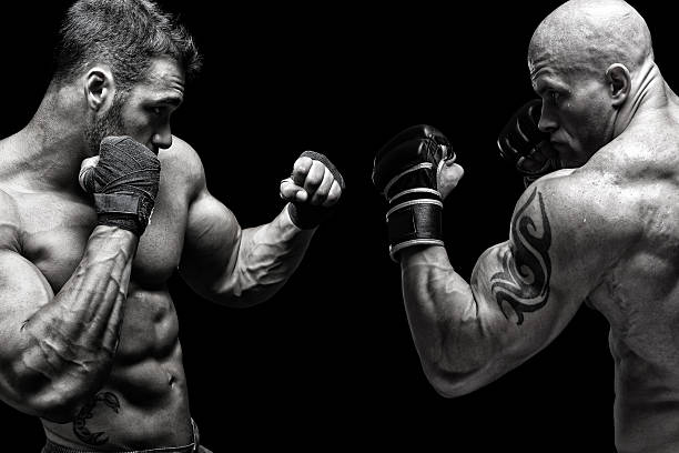 Fight Two fighters fighting in front of black background sportsman professional sport side view horizontal stock pictures, royalty-free photos & images