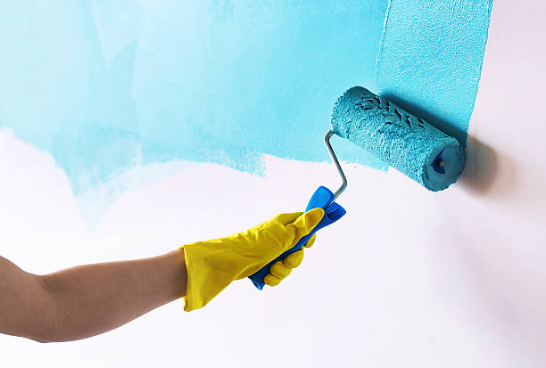 pintando a parede em ciano cor azul - house painter paint roller yellow painting - fotografias e filmes do acervo