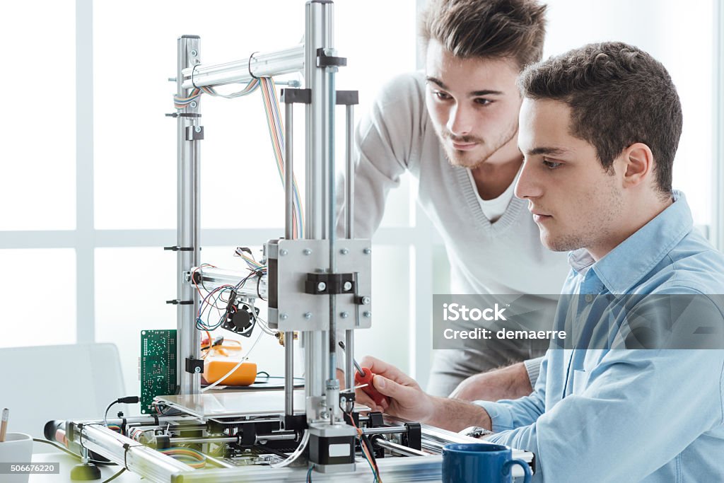 Young students using a 3D printer Young students in the laboratory using a 3D printer, technology and education concept Engineer Stock Photo