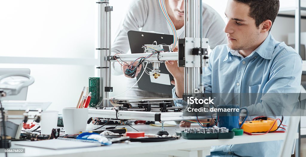 Engineering students using a 3D printer Engineering students using an innovative 3D printer in the laboratory Educational Exam Stock Photo