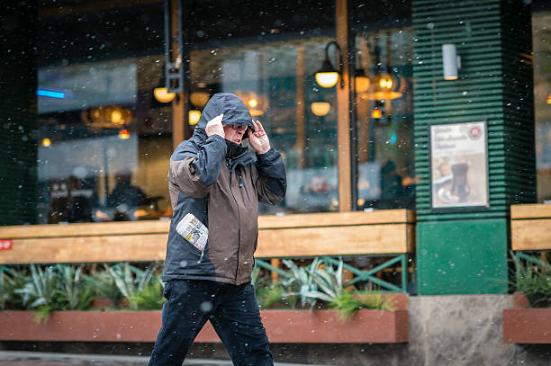 uomo in città a piedi, mentre nevichi - glasses stock market finance newspaper foto e immagini stock