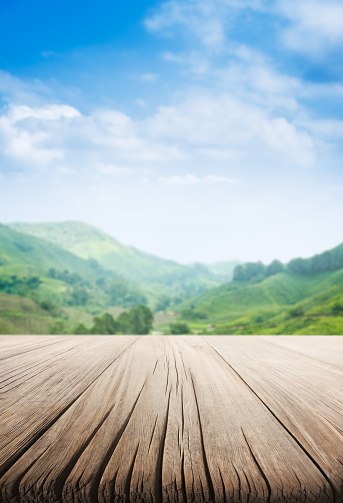 Empty wooden table, tea plantation and blue sky