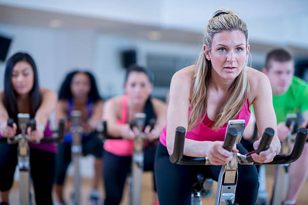 giro in bicicletta insieme in classe - spinning instructor exercising gym foto e immagini stock