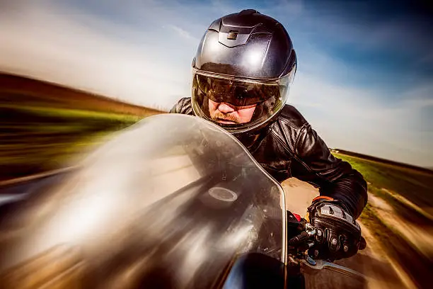 Photo of Biker racing on the road