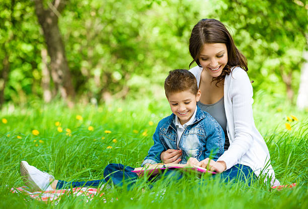 istock Mother and son with book in park 506691849