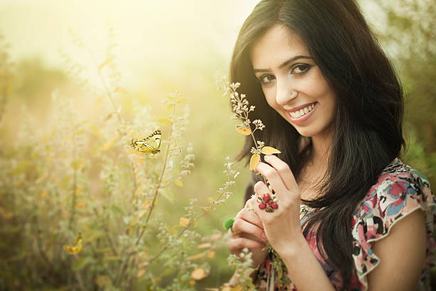 nahaufnahme der schöne glückliche junge frau in der natur mit grün - india women butterfly indian ethnicity stock-fotos und bilder