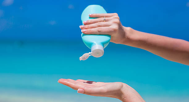 istock Woman hands putting sunscreen from a suncream bottle 506694241