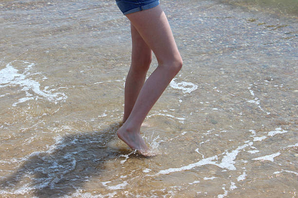 mädchen paddeln in wellen, beine, wasser, barfuß, seaside beach - human foot wading sea human toe stock-fotos und bilder