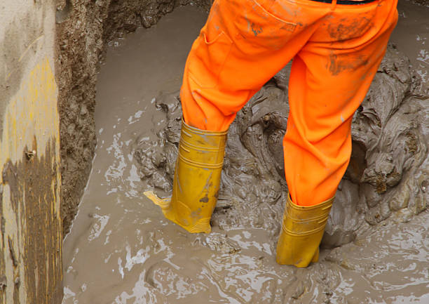istock worker boots in brown mud during the flood 506694765
