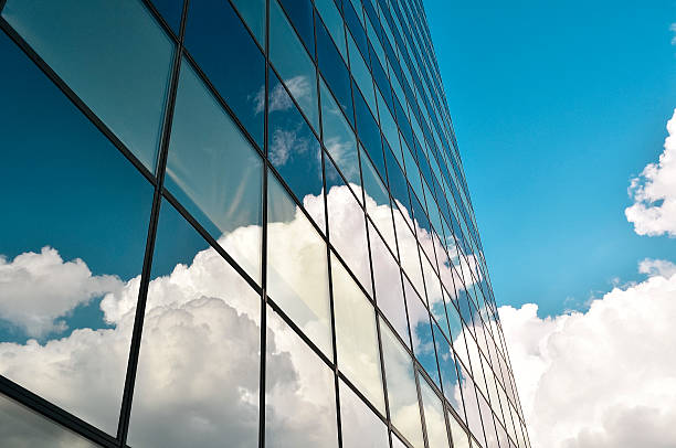 istock Dark blue office building glass facade with reflecting clouds 506694947